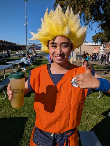 A customer smiling with a cup of cold-pressed sugarcane juice